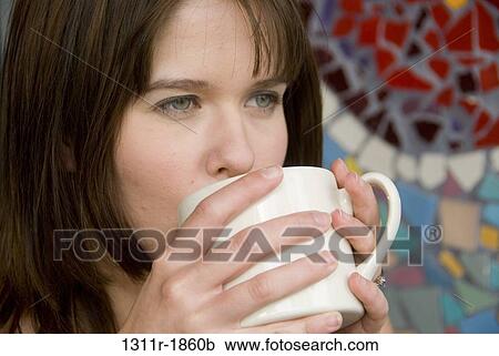 Stock Image - Close-up of a young woman drinking coffee. Fotosearch
