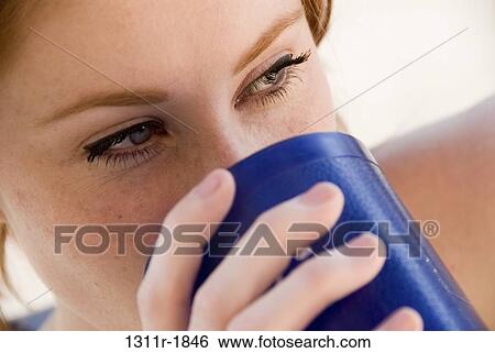 Close-up of a young woman drinking coffee View Large Photo Image Stock Photograph - Close-up of a young woman drinking coffee. Fotosearch