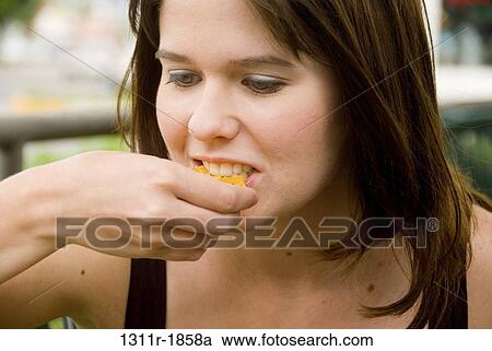 Close-up of a young woman eating food View Large Photo Image Stock Image - Close-up of a young woman eating food. Fotosearch