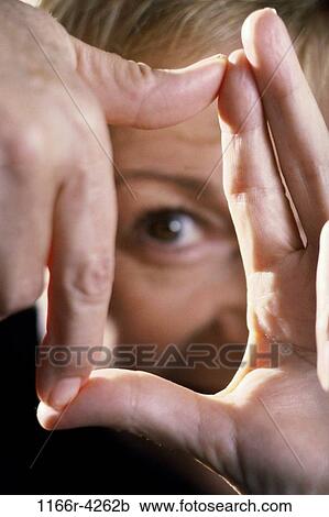 Stock Image - Close-up of a young woman making a frame with her hands. Fotosearch