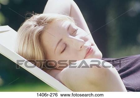 Stock Photograph - Close-up of a young woman sleeping in a chair. Fotosearch
