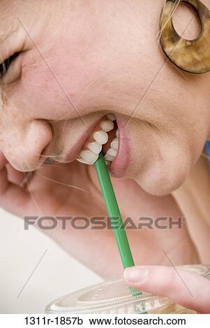 Close-up of a young woman talking on a mobile phone and sipping cold drink View Large Photo Image Stock Image - Close-up of a young woman talking on a mobile phone and sipping cold drink. Fotosearch