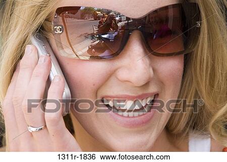 Close-up of a young woman talking on a mobile phone View Large Photo Image Stock Photograph - Close-up of a young woman talking on a mobile phone. Fotosearch