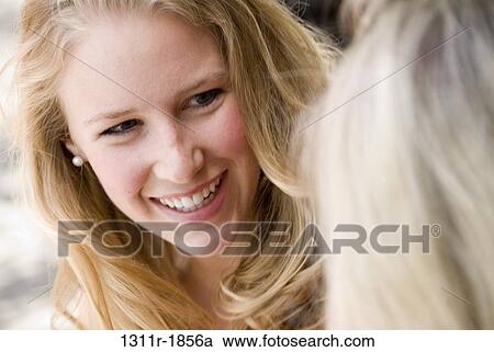 Stock Image - Close-up of a young woman talking with her mother. Fotosearch
