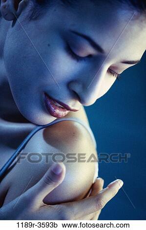 Close-up of a young woman touching her shoulder View Large Photo Image Stock Image - Close-up of a young woman touching her shoulder. Fotosearch