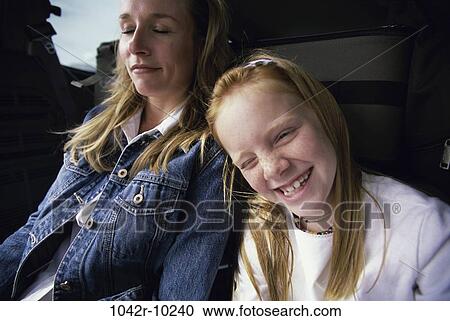 Close-up of girl smiling and sitting near her mother View Large Photo Image Stock Image - Close-up of girl smiling and sitting near her mother. Fotosearch