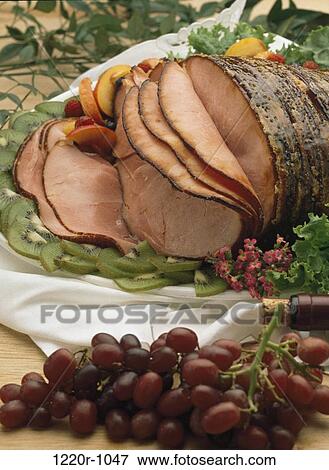 Stock Photo - Close-up of slices of roast beef with kiwi and grapes. Fotosearch