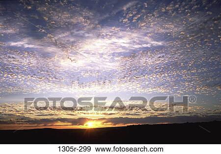 Stock Photo - Clouds in the sky at sunrise. Fotosearch