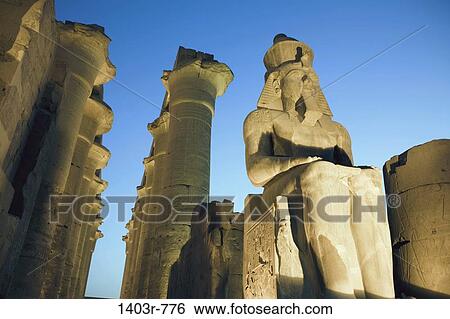 Stock Photograph - Colossal Seated Statue of Ramses II and Colonnade of Amenhotep III at night, Luxor Temple, Luxor, Egypt. Fotosearch