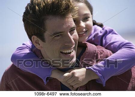 Daughter riding piggyback on her father View Large Photo Image Stock Photo - Daughter riding piggyback on her father. Fotosearch