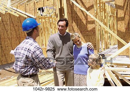 Family standing at a construction site shaking hands with a worker View Large Photo Image Stock Photography - Family standing at a construction site shaking hands with a worker. Fotosearch