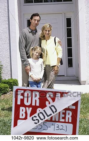 Family standing in front of a house with a sold sign View Large Photo Image Stock Image - Family standing in front of a house with a sold sign. Fotosearch