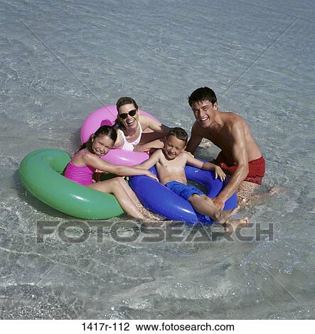 Father and mother playing with their daughter and son at the beach View Large Photo Image Stock Image - Father and mother playing with their daughter and son at the beach. Fotosearch