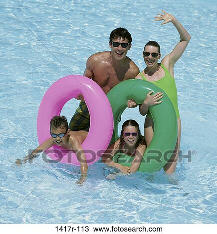 Father and mother with their daughter and son in a swimming pool View Large Photo Image Stock Image - Father and mother with their daughter and son in a swimming pool. Fotosearch