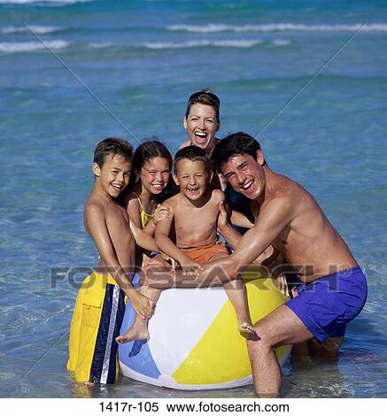 Stock Photography - Father and mother with their daughter and sons at the beach. Fotosearch