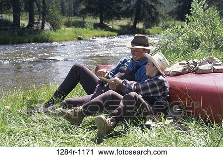 Father and son sitting by a river View Large Photo Image Stock Image - Father and son sitting by a river. Fotosearch