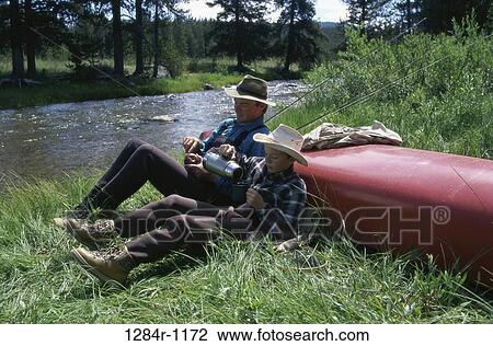 Father and son sitting by a river View Large Photo Image Stock Image - Father and son sitting by a river. Fotosearch