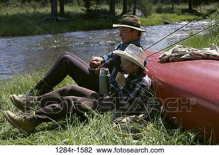Father and son sitting by a river View Large Photo Image Stock Image - Father and son sitting by a river. Fotosearch