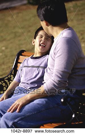 Stock Photo - Father and son sitting on a park bench. Fotosearch