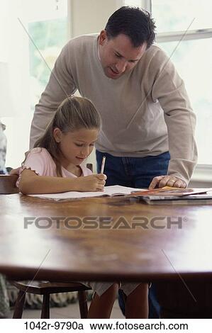 Father assisting his daughter with her homework View Large Photo Image Stock Image - Father assisting his daughter with her homework. Fotosearch