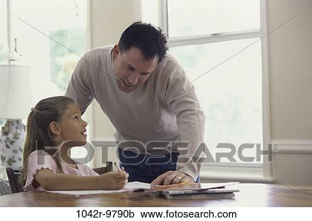 Father assisting his daughter with her homework View Large Photo Image Stock Image - Father assisting his daughter with her homework. Fotosearch