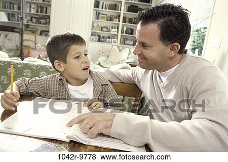 Stock Photo - Father assisting his son with his homework. Fotosearch