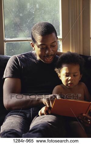 Father helping his son read a book View Large Photo Image Stock Photography - Father helping his son read a book. Fotosearch