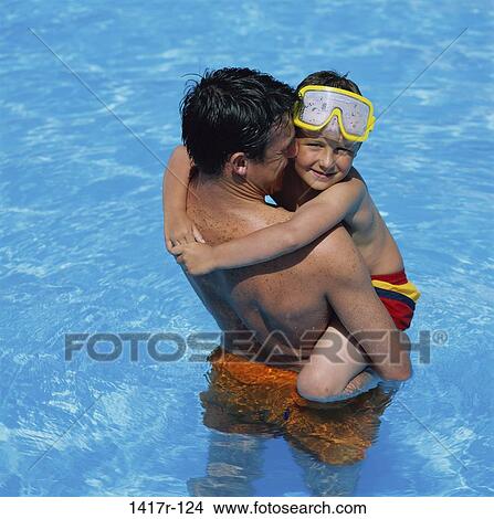 Father holding his son in a swimming pool View Large Photo Image Picture - Father holding his son in a swimming pool. Fotosearch