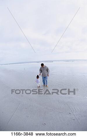 Father walking with his daughter on the beach View Large Photo Image Stock Photo - Father walking with his daughter on the beach. Fotosearch