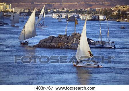 Feluccas sail on the Nile River at Aswan, Egypt View Large Photo Image Stock Photo - Feluccas sail on the Nile River at Aswan, Egypt. Fotosearch