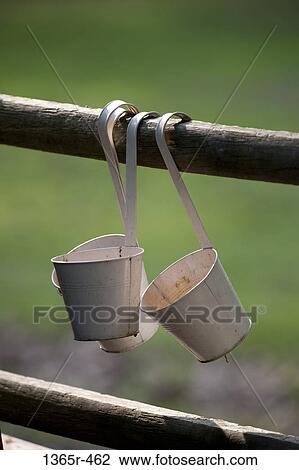 Stock Image - Flower pots hanging on fence. Fotosearch