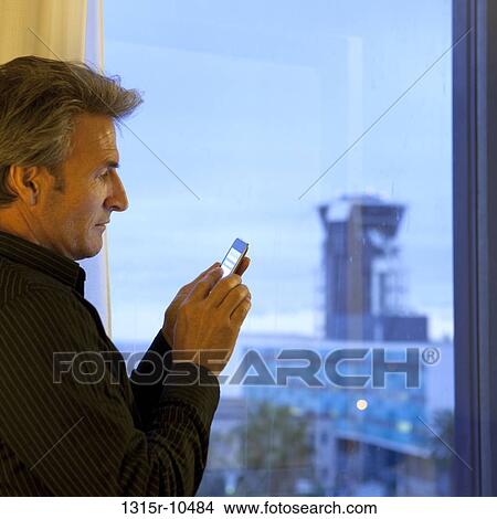 France, Nice, Businessman checking text message at airport hotel View Large Photo Image Picture - France, Nice, Businessman checking text message at airport hotel. Fotosearch