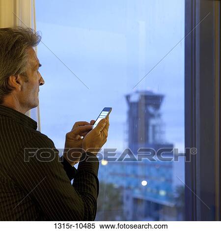 France, Nice, Businessman checking text message at airport hotel View Large Photo Image Stock Photography - France, Nice, Businessman checking text message at airport hotel. Fotosearch