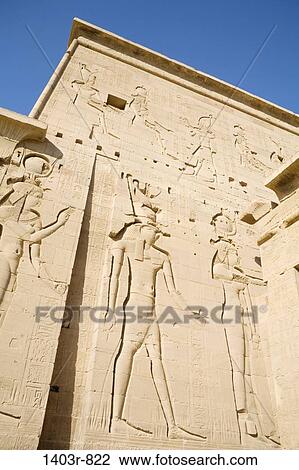 Giant carvings on the first pylon at the Temple of Isis. Located on Philae Island in the Nile River at Aswan, the Temple of Isis draws tourists from around the world. View Large Photo Image Stock Image - Giant carvings on the first pylon at the Temple of Isis. Located on Philae Island in the Nile River at Aswan, the Temple of Isis draws tourists from around the world.. Fotosearch