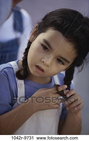 Girl braiding her hair View Large Photo Image Stock Image - Girl braiding her hair. Fotosearch