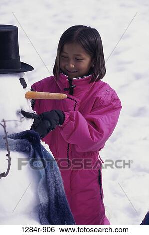 Girl making a snowman View Large Photo Image Stock Photograph - Girl making a snowman. Fotosearch