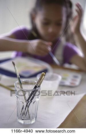 Stock Image - Girl painting with watercolor paints. Fotosearch