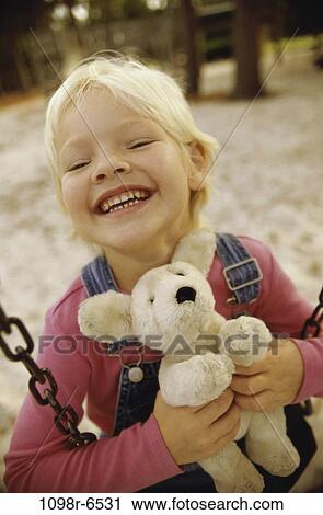 Girl sitting on a swing holding a teddy bear View Large Photo Image Stock Image - Girl sitting on a swing holding a teddy bear. Fotosearch