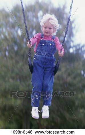 Girl sitting on a swing View Large Photo Image Stock Photograph - Girl sitting on a swing. Fotosearch