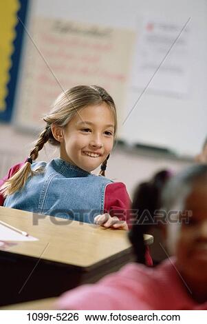 Stock Photograph - Girl smiling in a classroom. Fotosearch