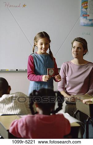 Girl standing at the front of the class during show-and-tell View Large Photo Image Stock Image - Girl standing at the front of the class during show-and-tell. Fotosearch