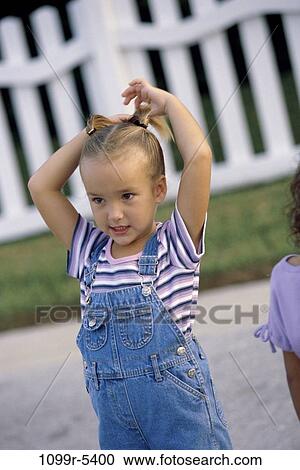 Girl standing with her hands on her head View Large Photo Image Stock Image - Girl standing with her hands on her head. Fotosearch
