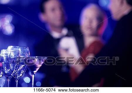 Glasses on a bar with people in the background View Large Photo Image Picture - Glasses on a bar with people in the background. Fotosearch