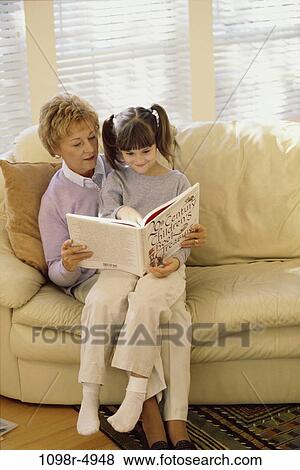 Grandmother reading a book with her granddaughter View Large Photo Image Stock Photo - Grandmother reading a book with her granddaughter. Fotosearch