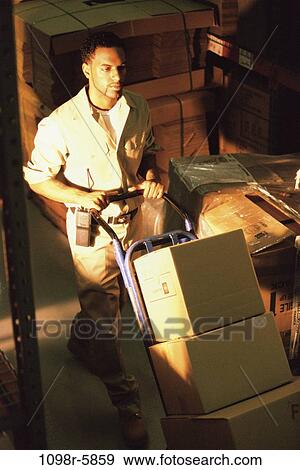 High angle view of a delivery man pushing boxes in a warehouse View Large Photo Image Stock Photo - High angle view of a delivery man pushing boxes in a warehouse. Fotosearch