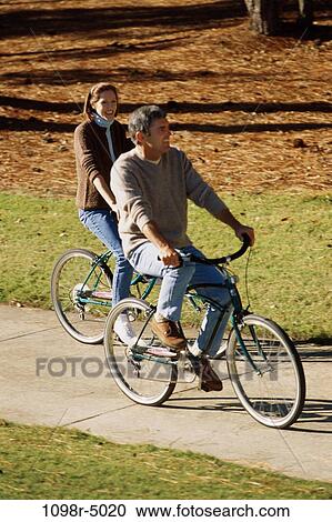 Stock Image - High angle view of a mid adult couple riding bicycles. Fotosearch