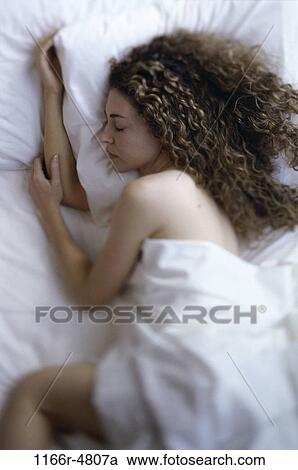 High angle view of a young woman sleeping in a bed View Large Photo Image Stock Image - High angle view of a young woman sleeping in a bed. Fotosearch
