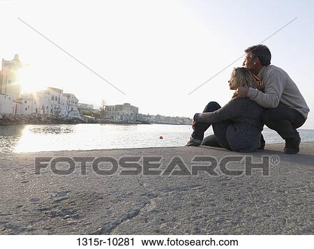 Italy, Campania, Ischia, Couple watch sunset from stone pier View Large Photo Image Stock Image - Italy, Campania, Ischia, Couple watch sunset from stone pier. Fotosearch