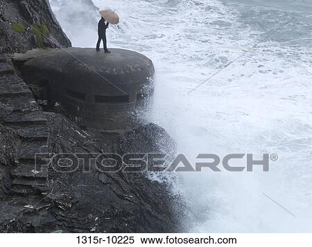 Italy, Liguria, Cinque Terre, Monterosso al Mare, Man standing on WW2 concrete bunker with umbrella View Large Photo Image Stock Photography - Italy, Liguria, Cinque Terre, Monterosso al Mare, Man standing on WW2 concrete bunker with umbrella. Fotosearch