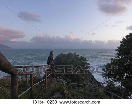 Italy, Liguria, Cinque Terre, Vernazza, Man looking at sea View Large Photo Image Stock Image - Italy, Liguria, Cinque Terre, Vernazza, Man looking at sea. Fotosearch